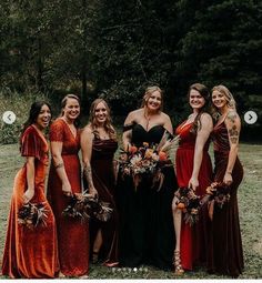 a group of women standing next to each other wearing dresses and holding bouquets in their hands