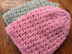 three crocheted hats sitting on top of a wooden floor