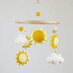 a yellow and white mobile with sun, clouds and stars