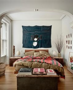 a bed sitting in a bedroom next to a wooden table with books on top of it