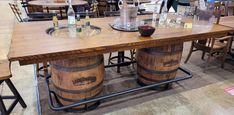 two wooden barrels sitting on top of each other in front of tables with chairs around them