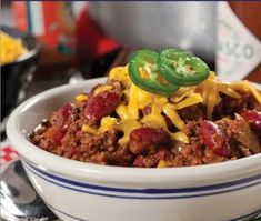 a white bowl filled with chili and cheese