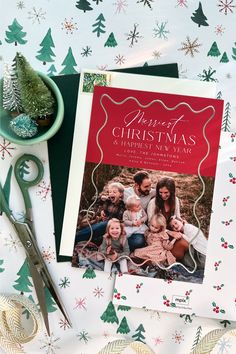 a christmas card sitting on top of a table next to a pair of scissors