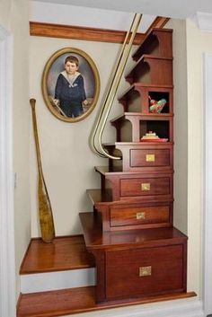 a staircase with wooden steps leading up to a portrait on the wall