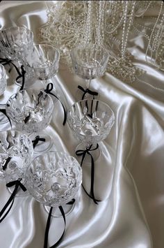 several crystal vases with black ribbons on a white cloth