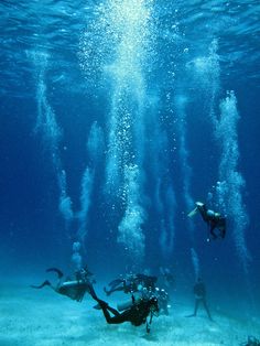 two people swimming in the ocean with lots of bubbles coming out of their mouths and water around them