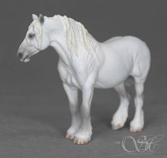 a white toy horse standing on top of a table