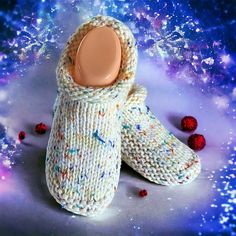 a pair of knitted slippers sitting on top of a purple surface with stars in the background