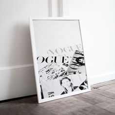 a black and white photograph sitting on top of a wooden floor next to a door