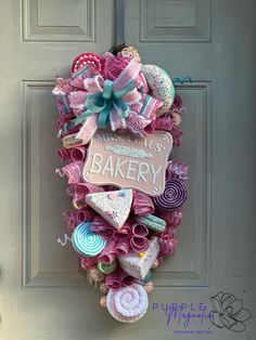 a door hanger decorated with pink, blue and white items that spell out bakery