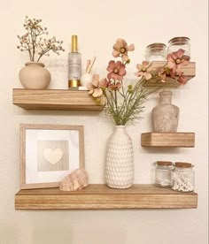 two wooden shelves with vases and other items on them, one is holding flowers