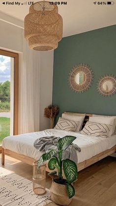 a bed room with a neatly made bed next to a large sliding glass door and a potted plant