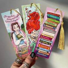 the little mermaid bookmarks are being held by someone