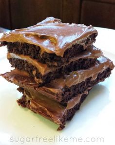 three pieces of chocolate cake sitting on top of a white plate covered in frosting