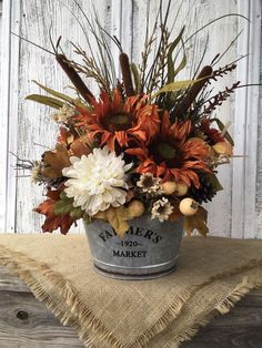 a bucket filled with lots of flowers on top of a table