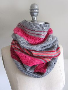 a gray and pink scarf sitting on top of a white mannequin