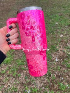 a hand holding a pink glittered coffee cup