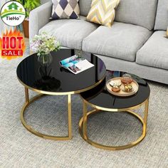 two tables sitting on top of a carpeted floor in front of a gray couch