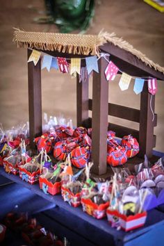 a table topped with lots of candy and candies next to a small wooden structure