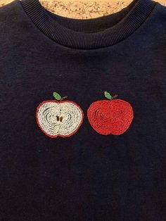 an apple and a worm appliqued on a sweater