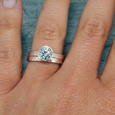 a woman's hand with a ring on it and a diamond in the middle