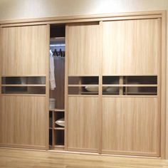 an empty closet with wooden doors and shelves