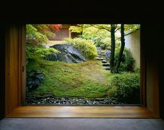 an open window showing a garden with steps leading up to the top of a hill