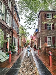 a woman is walking down the street with an umbrella