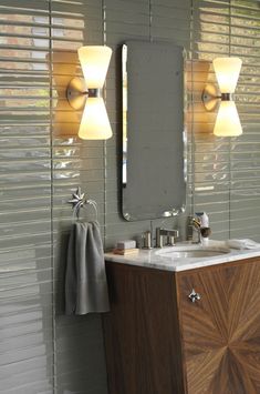 a bathroom vanity with two lights and a mirror