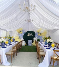 a table set up for a party with white and yellow decorations