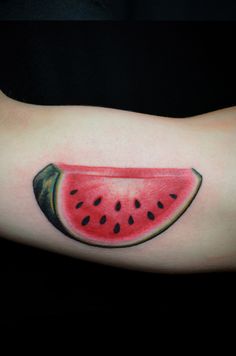 a watermelon slice tattoo on the arm