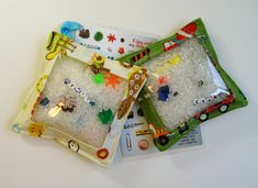 two small trays filled with white rice covered in different types of magnets and beads