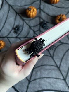 a hand holding an open book with a black turtle on it