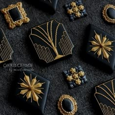 some black and gold decorated cookies are on the floor together with other decorations around them