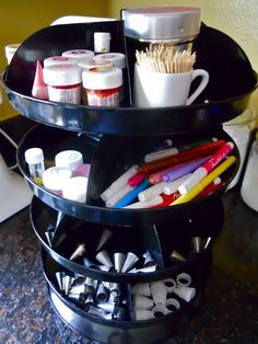 the three tiered tray is filled with crafting supplies