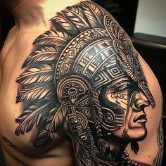 a man with a tattoo on his shoulder and headdress