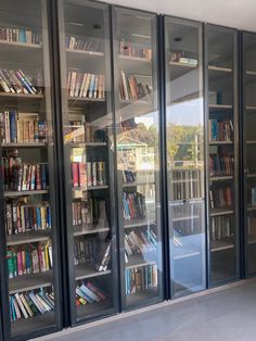 a room filled with lots of books on top of glass shelves next to each other