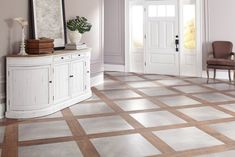 a living room with white walls and beige flooring on the tile, along with a chair