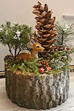 a deer figurine sitting on top of a tree stump surrounded by pine cones