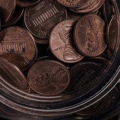 a glass jar filled with lots of different types of coins