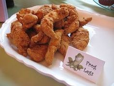 fried food on a plate with a sign that says frog legs in front of it