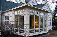 a small white house with windows and a porch