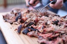 a person cutting meat with a knife and fork