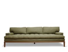 a green couch sitting on top of a wooden frame