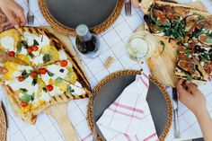 several people are eating pizza at a table