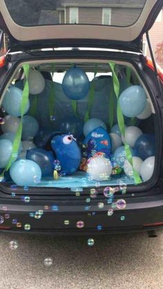 an open hatchback car with balloons and streamers in the trunk