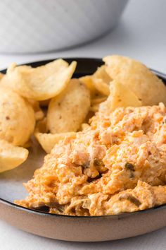 a bowl filled with potato chips and chicken salad