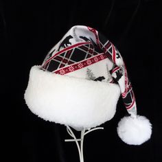 "Black bear striped Santa Claus hat makes for a novel Christmas holiday look for the a woodland Santa. The hat is made of a soft cotton flannel, trimmed with a snowy white Sherpa faux fur fabric trim and topped with a snowy white faux fur pom pom. The hat will fit most adult and teen head sizes, It is cone shaped slouchy styling like the traditional Santa hat and the opening for your head is 24- 25\". The length of the hat is 19\". Be sure to check head measurement to be sure of good fit for you Casual Christmas Hat, One Size Fits Most, White Christmas Cap, White Christmas Holiday Hat, Cow Santa Hat, Rabbit Santa Hat, Silver Santa Hat, Christmas Party Hat, Faux Fur Santa Hat, Lodge Christmas