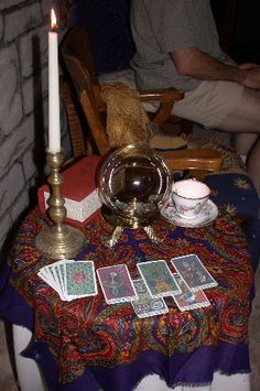 a table topped with cards and a candle