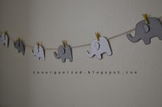 an elephant banner hanging on a clothes line with wooden pegs in the shape of elephants